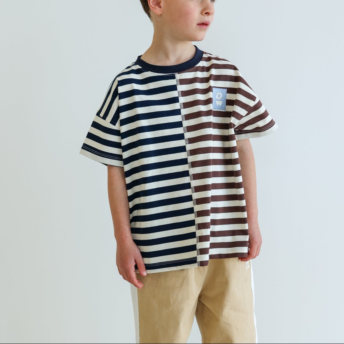 Children’s oversized organic cotton Split Stripes Tee by OLLE, with yarn-dyed stripe panels, contrast stitch, and chest embroidery.