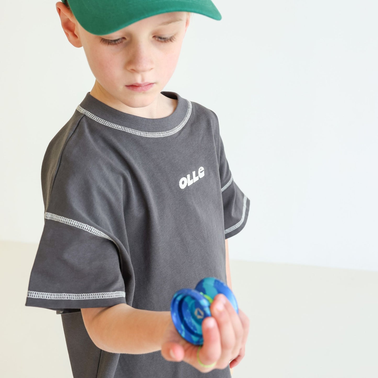 Children’s oversized organic cotton Topstitch Tee in Charcoal by OLLE, with contrast stitch and skate logo.