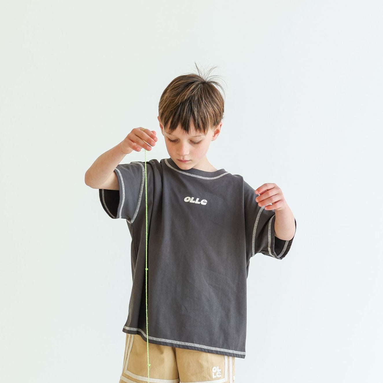 Children’s oversized organic cotton Topstitch Tee in Charcoal by OLLE, with contrast stitch and skate logo.