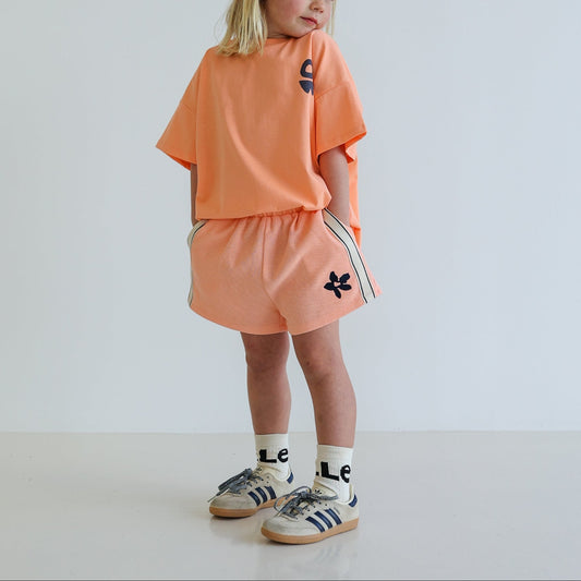Children’s organic cotton Waffle Short by OLLE, with contrast side seam tape, embroidery, and relaxed shorter fit