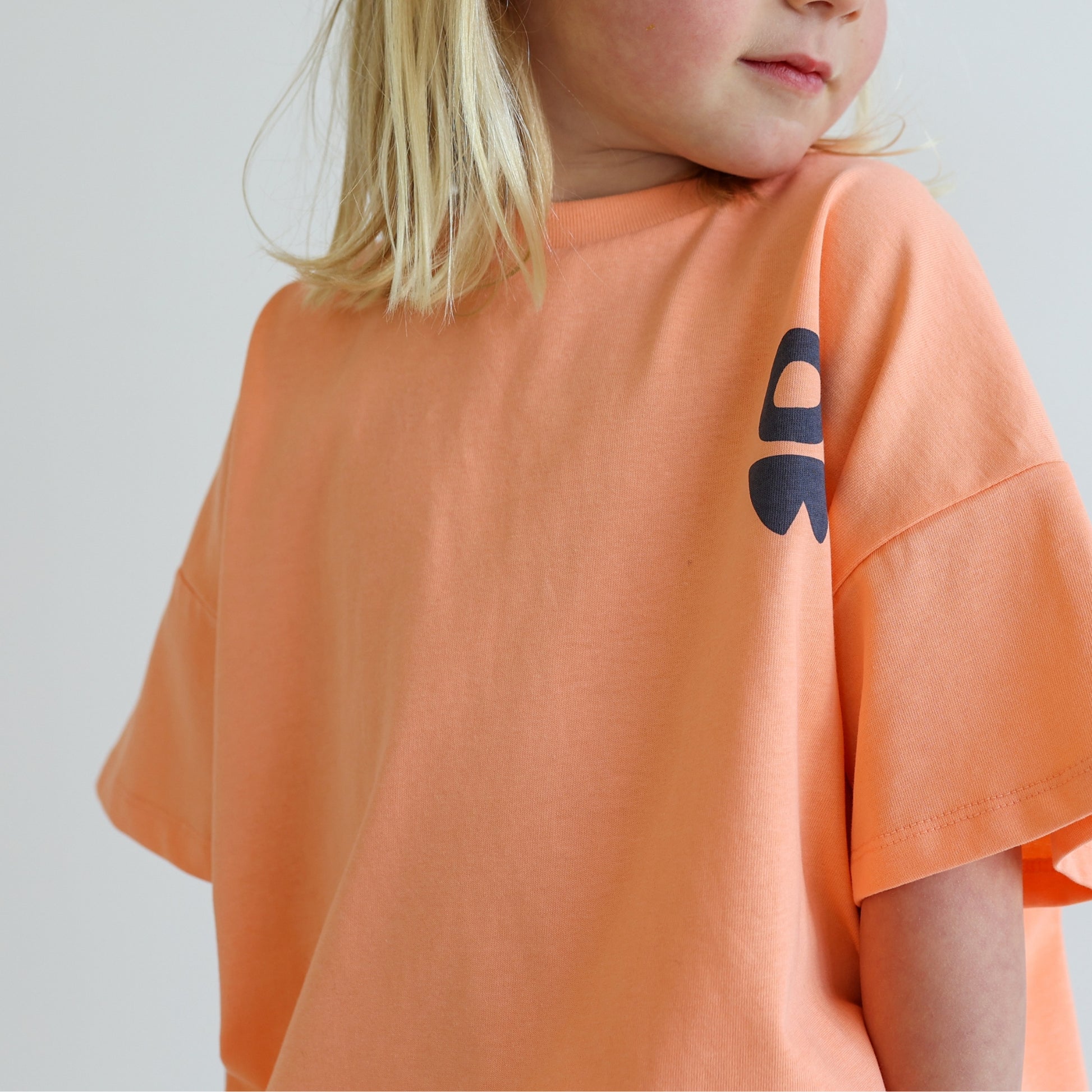 Children’s oversized organic cotton It’s Cool Tee by OLLE, with ‘It’s cool to care’ motto printed on back.