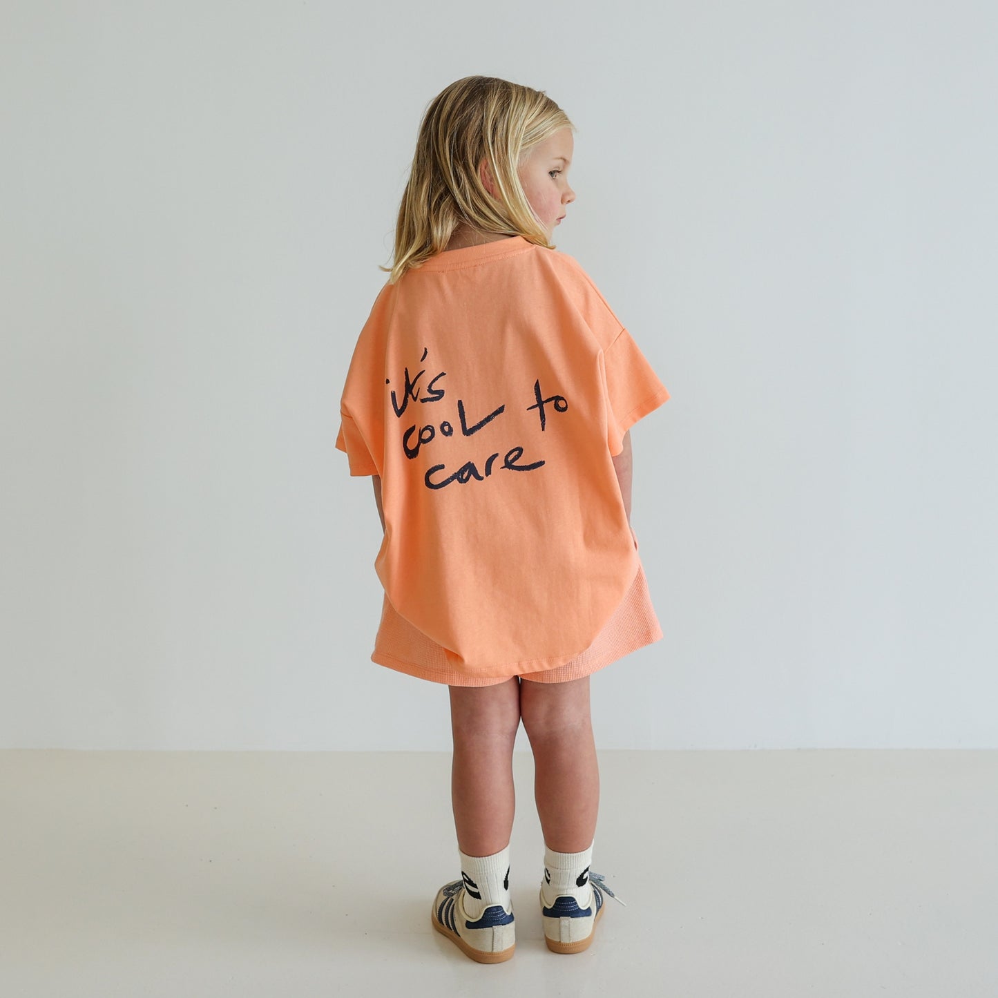 Children’s oversized organic cotton It’s Cool Tee by OLLE, with ‘It’s cool to care’ motto printed on back.