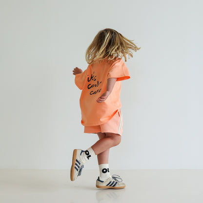 Children’s oversized organic cotton It’s Cool Tee by OLLE, with ‘It’s cool to care’ motto printed on back.