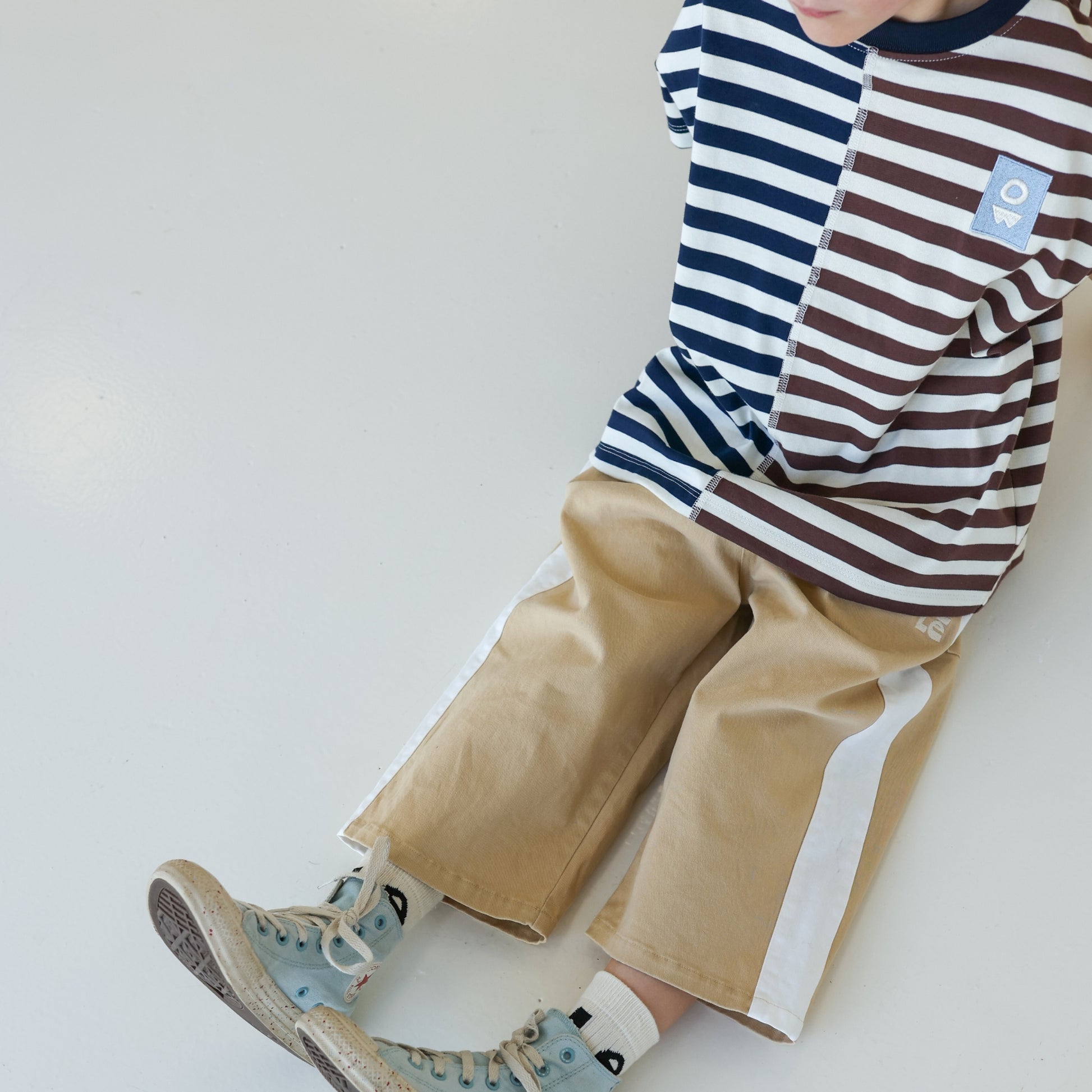 Children’s oversized organic cotton Split Stripes Tee by OLLE, with yarn-dyed stripe panels, contrast stitch, and chest embroidery.