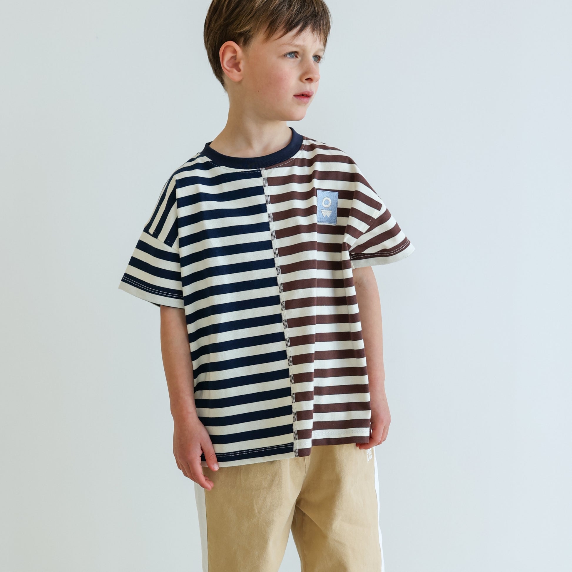Children’s oversized organic cotton Split Stripes Tee by OLLE, with yarn-dyed stripe panels, contrast stitch, and chest embroidery.