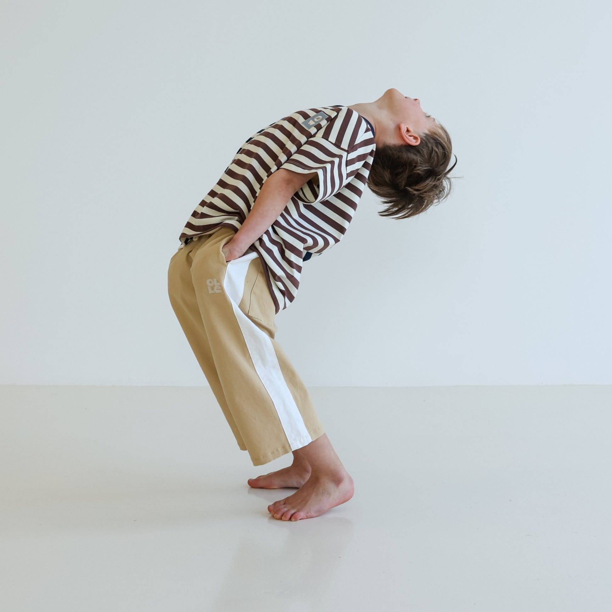 Children’s oversized organic cotton Split Stripes Tee by OLLE, with yarn-dyed stripe panels, contrast stitch, and chest embroidery.