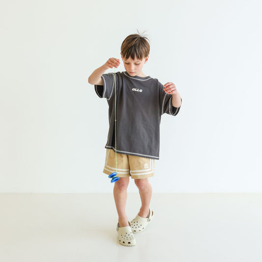 Children’s oversized organic cotton Topstitch Tee in Charcoal by OLLE, with contrast stitch and skate logo.